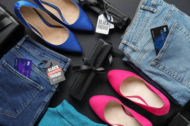 Skład ze stylowymi kobiecymi ubraniami, butami i pudełkami na ciemnym tle, zbliżenie. Wyprzedaż Black Friday - Zdjęcie, obraz