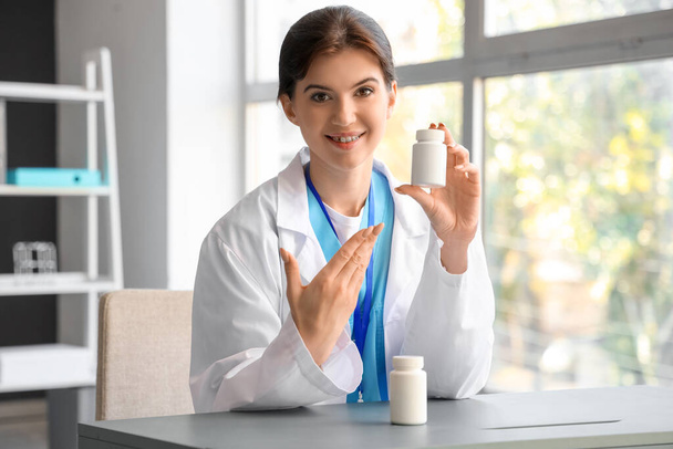 Femme médecin avec bouteille de pilule vidéo bavardage au bureau - Photo, image