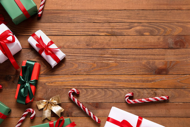 Kerstcadeaudozen en snoepstokken op houten ondergrond - Foto, afbeelding