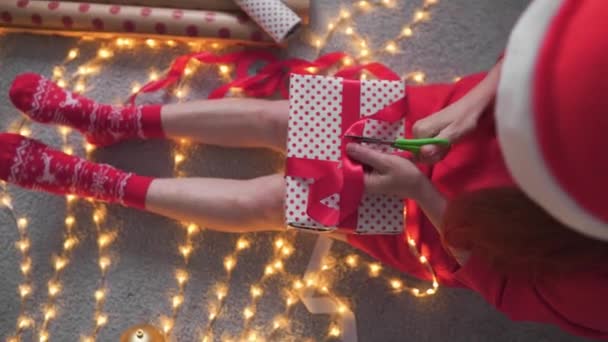 Egy nő különleges részletekkel és gazdag figyelemmel ajándékoz karácsonyra. Úgy döntött, hogy ajándékba adja a családjának és közeli barátainak, és az arca örömöt és hálát fejez ki. Kiváló minőség - Felvétel, videó
