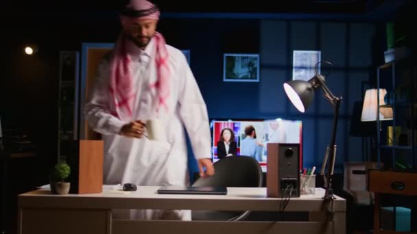 Άραβας υπάλληλος που φθάνουν σε κομψό διαμέρισμα προσωπικό γραφείο, ξεκινώντας σημαντικές εργασίες εργασίας. Εστιασμένη δακτυλογράφηση μουσουλμάνων τηλεργαζομένων στο πληκτρολόγιο laptop, έναρξη βάρδιας εργασίας στο σπίτι - Πλάνα, βίντεο