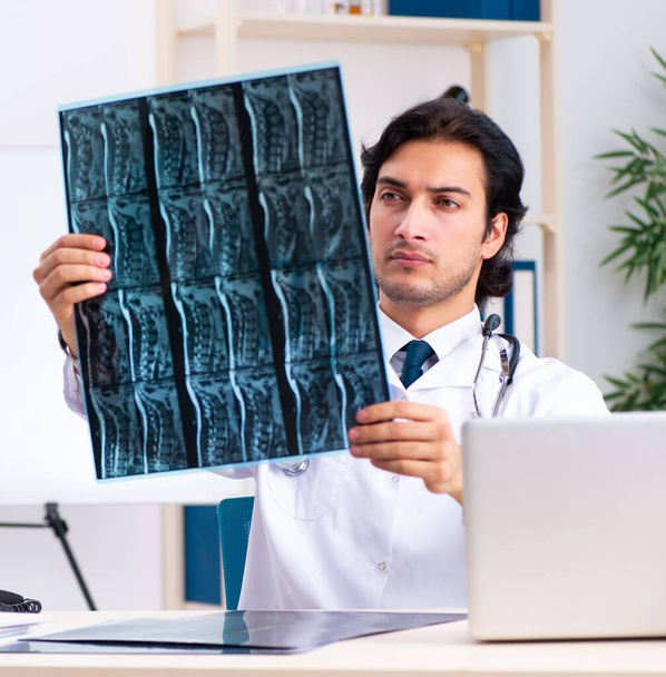 Der junge gutaussehende Arzt Radiologe arbeitet in der Klinik - Foto, Bild
