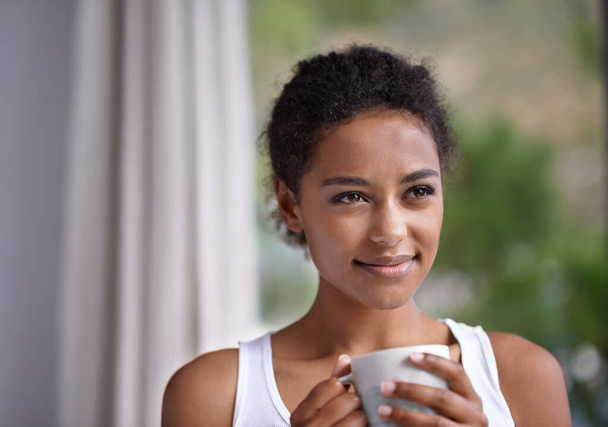 Nothing beats a relaxing warm morning drink. a young woman enjoying a cup of coffee - Photo, Image
