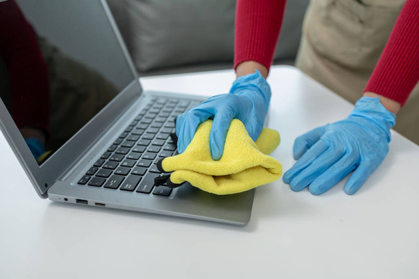 Conserje limpiando la oficina, Limpie el cuaderno con un trapo, use guantes y limpie con una toalla, Use guantes de goma cuando trabaje con productos químicos de limpieza, idea de limpieza. - Foto, Imagen
