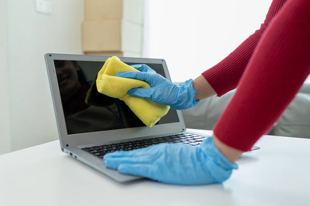 Уборщик чистки офиса, очистить ноутбук с тряпкой, носить перчатки и вытирать полотенцем, носить резиновые перчатки при работе с чистящими химикатами, идея очистки. - Фото, изображение