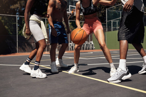 Ты должен быть быстрым на ногах. Крупный план группы спортивных молодых людей, играющих в баскетбол на спортивной площадке - Фото, изображение