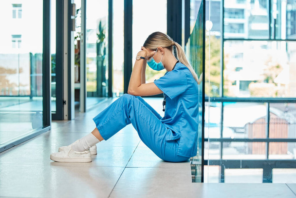 Haciendo lo que amo pero a qué costo. una joven doctora que parece cansada mientras trabaja en un hospital moderno - Foto, Imagen