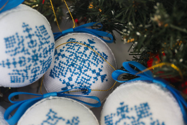 Mavi kar taneleriyle süslenmiş Noel topları haçla işlenmiş. - Fotoğraf, Görsel