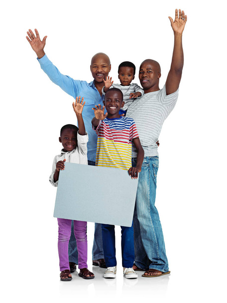 Χαίρομαι που είμαστε μαζί. Στιγμιότυπο δύο Αφρικανών ανδρών με τα παιδιά τους να κρατούν μια λευκή σανίδα, απομονωμένα στα λευκά. - Φωτογραφία, εικόνα