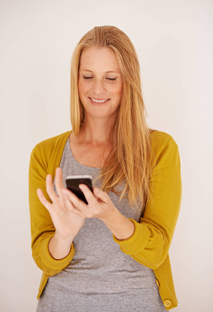 Звантаження нової програми так просто. щаслива жінка, що надсилає текстове повідомлення на свій мобільний телефон - Фото, зображення