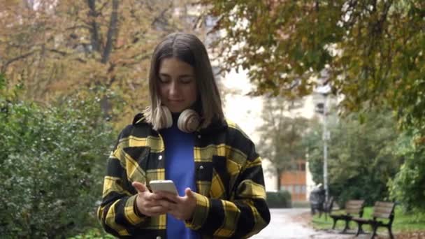 Stijlvol tienermeisje in hoofdtelefoon op straat van Wroclaw, Polen - Video