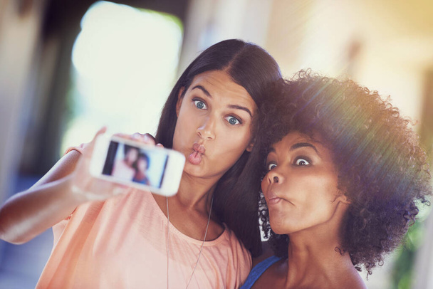 Crazy memories worth remembering. two girlfriends taking a selfie on a mobile phone - Photo, Image