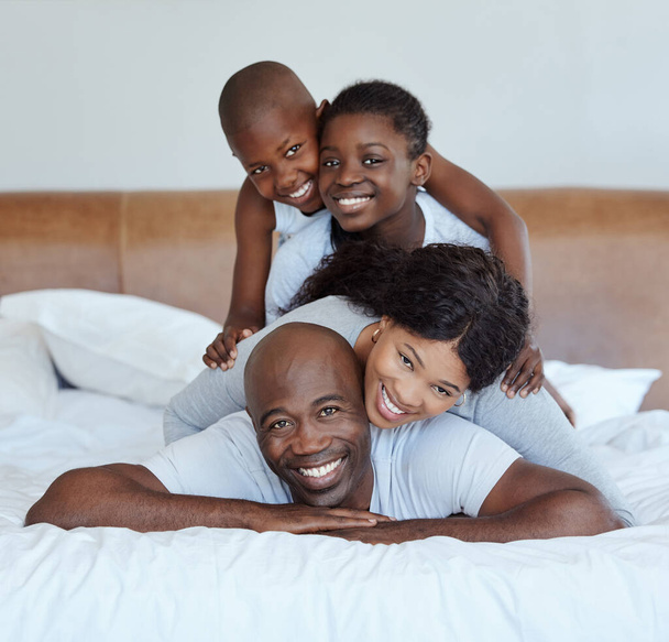 家族は重要なものではない. そのすべて. 一緒にベッドで結ばれる美しい若い家族 - 写真・画像