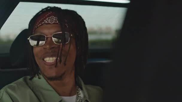 Peito de jovem afro-americano com dreadlocks rap no banco de trás do carro - Filmagem, Vídeo