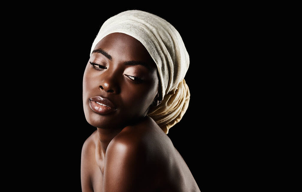 Zijdezachte gladde huid. Studio shot van een mooie vrouw met een hoofddoek tegen een zwarte achtergrond - Foto, afbeelding