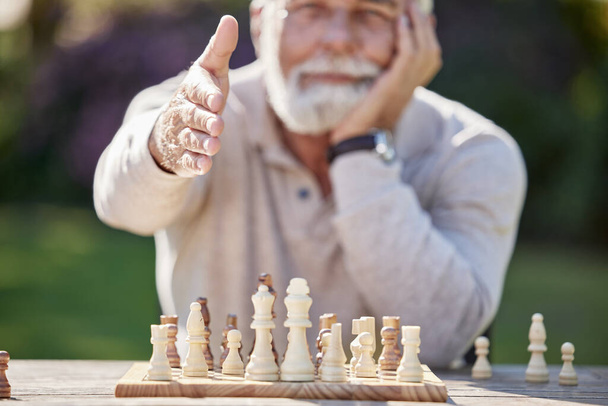 Зустрічайтеся з містером Шахами. старший чоловік тягнеться потиснути руки, граючи в шахи на вулиці - Фото, зображення