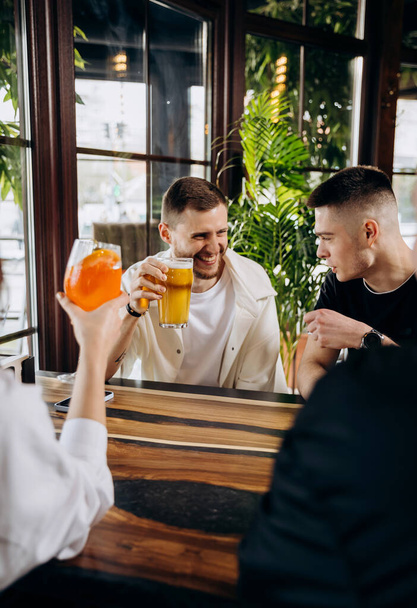 Conceito de estilo de vida de bebidas com caras e meninas se divertindo juntos no restaurante bar cervejaria - Foto, Imagem
