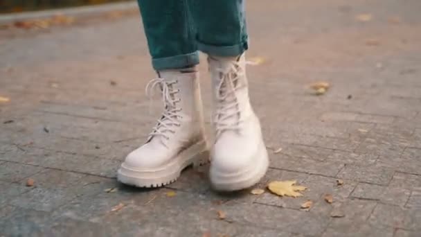 Lady περπάτημα κατά μήκος του πεζόδρομου στο πάρκο της πόλης, φορώντας κομψές μπότες. Ψιλοκομμένο. Φθινόπωρο αστικό στυλ μόδας δρόμο. Φθινοπωρινή. Πραγματικός χρόνος - Πλάνα, βίντεο
