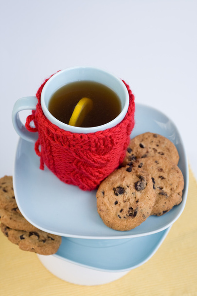 Синя чашка з червоною в'язаною обкладинкою та печивом з шоколадом
 - Фото, зображення