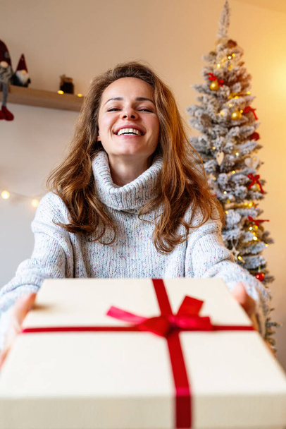 Mujer feliz recibiendo regalo de Navidad. Temporada de entrega. - Foto, imagen