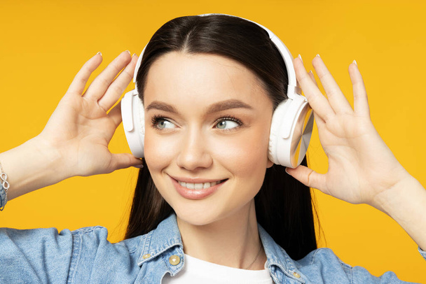 Attraente giovane donna che ascolta musica in cuffia - Foto, immagini