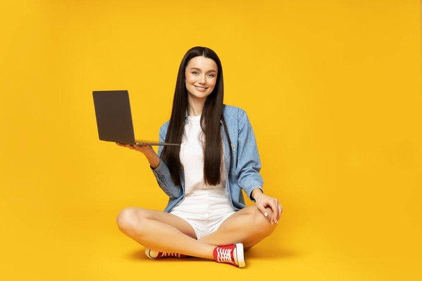 A cute young woman with a laptop in her hands - Photo, Image