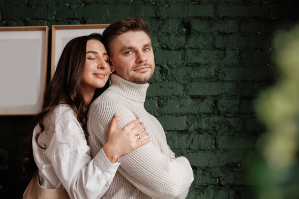 Valentine's day. Happy loving couple hugging gentle at cozy Scandinavian home. Young man and woman with healthy relationships enjoying spending time together on romantic date, celebrating anniversary. - Fotografie, Obrázek