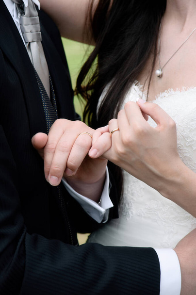 Ręce nowożeńców z przeplatającymi się paluszkami i obrączkami - Zdjęcie, obraz