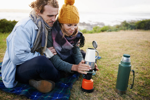 Vamos a calentar este café. una joven pareja calentando una olla de café al aire libre - Foto, imagen