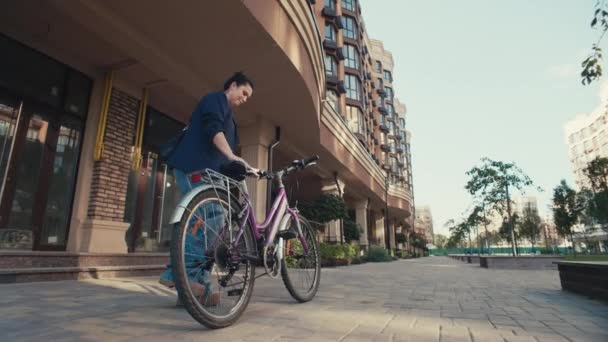 Pionieristico Pendolarismo Sostenibile: una donna in affari che pedala attraverso il paesaggio urbano per raggiungere il suo ufficio. Filmati 4k di alta qualità - Filmati, video