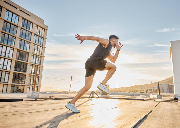 Create good habits and achieve your goals. a sporty young man out on a rooftop for a workout - Photo, Image