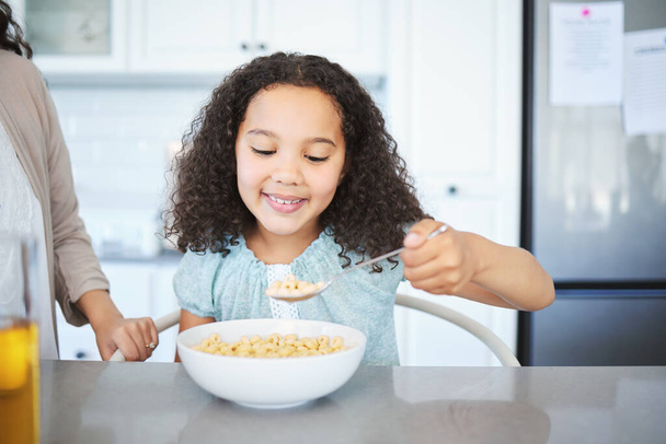 Wach hungrig auf. ein entzückendes kleines Mädchen frühstückt am Küchentisch - Foto, Bild