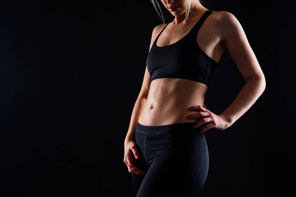 Молодая женщина, позирует в студии. Рекламная спортивная одежда и одежда для йоги. Здоровый образ жизни, спорт - Фото, изображение