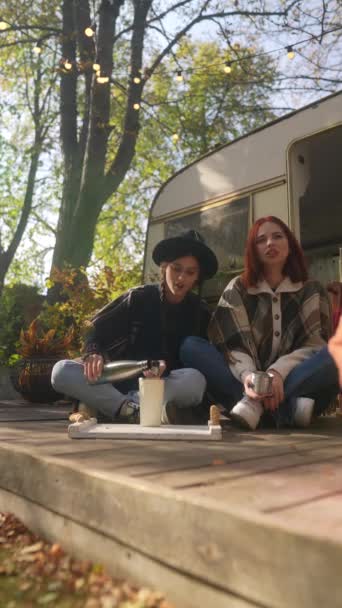 Dvě dívky v hippie oblečení si vychutnávají horký čaj na slunné terase během podzimu. Vysoce kvalitní 4K záběry - Záběry, video