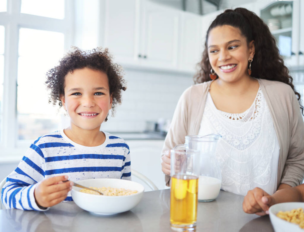 Setzen Sie sich zu uns, es gibt genug. Mutter und Sohn frühstücken zu Hause am Küchentisch - Foto, Bild