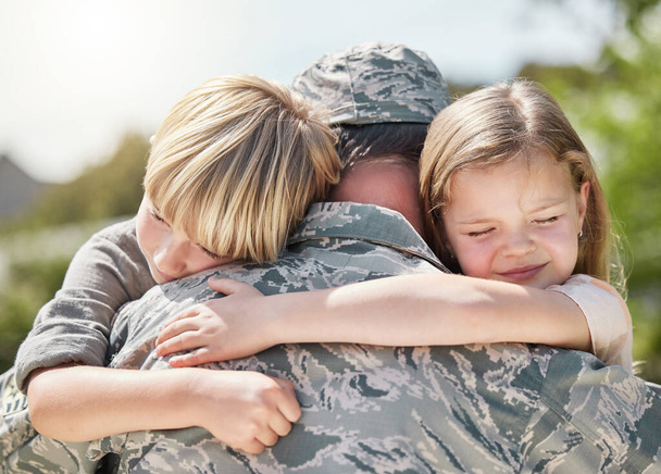 Мир, как выяснилось, не любит тебя, как твою семью. Отец, возвращающийся из армии, обнимает своих детей снаружи - Фото, изображение