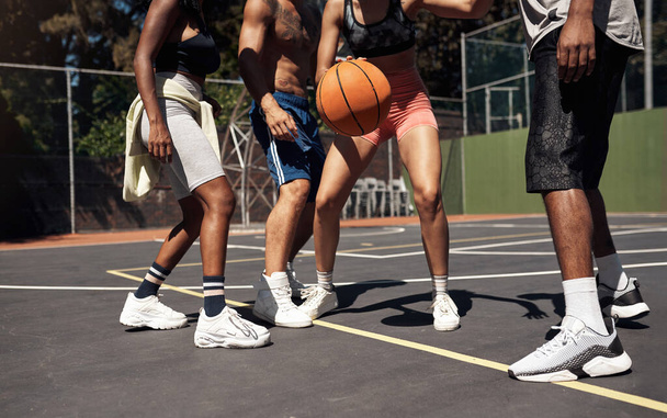 Koripallossa on kyse tasapainosta ja koordinoinnista. lähikuva ryhmä urheilullisia nuoria pelaamassa koripalloa urheilukentällä - Valokuva, kuva