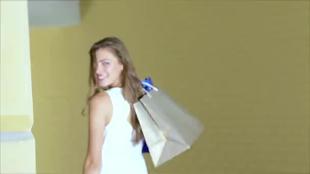 Dziewczyn trzymając zakupy torby i chodzić po sklepach. Uśmiechnięte dziewczyny zabawy razem. - Materiał filmowy, wideo