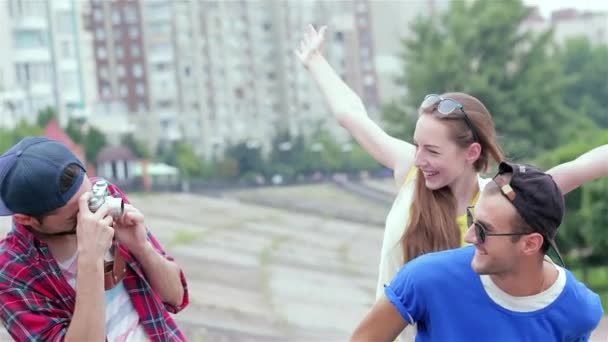 Junge Freunde amüsieren sich gemeinsam auf der Straße und lächeln sich an. Angenehmer Tag im Leben von drei Freunden. - Filmmaterial, Video