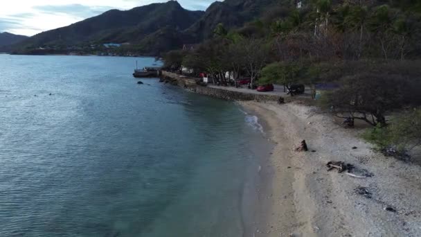 Luftaufnahme von Menschen, die in der Sonne baden, schwimmen und am Strand spielen. Draufsicht von der Drohne am Strand und am azurblauen Meer - Filmmaterial, Video