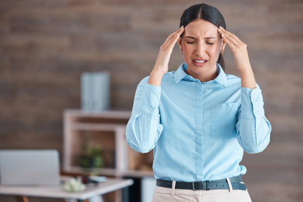 Schöne gemischte Rasse Geschäft leidet unter Kopfschmerzen, während sie in ihrem Büro stehen. Junge Angestellte eines Unternehmens, die bei der Arbeit mit Migräne zu kämpfen haben. Der Stress und die Angst vor Termindruck. - Foto, Bild