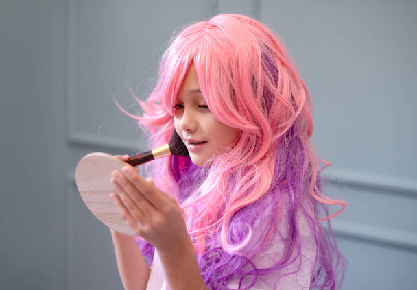 Vanille meisje. Kawaii vibes. Barbie stijl. Snoep kleuren ontwerp. klein meisje met roze haar doet make-up - Foto, afbeelding