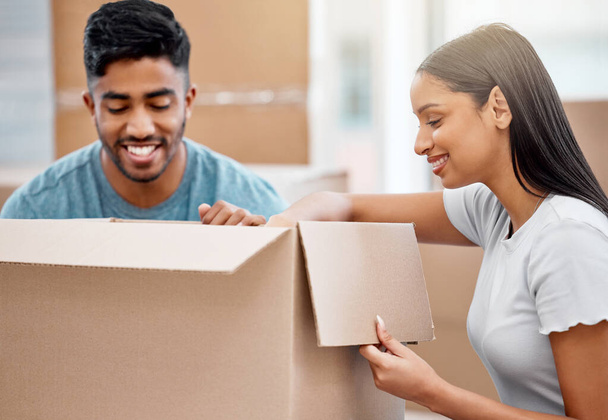 ¿Dónde ponemos esto? una joven pareja desempacando cajas juntas en su nuevo hogar - Foto, imagen