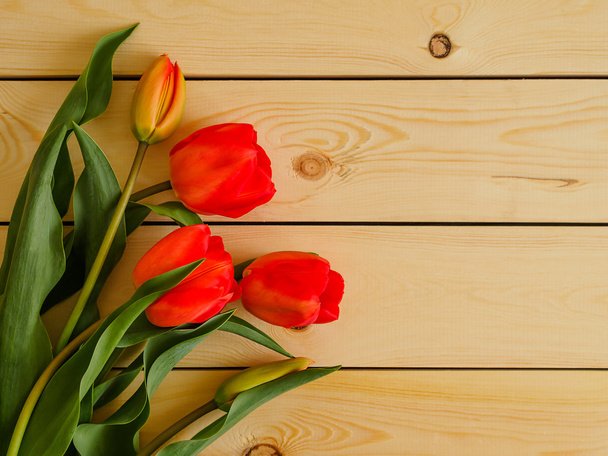 Red tulips on wooden background - Фото, изображение