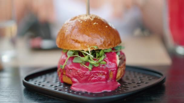 Close up hambúrguer com molho vermelho e microplantas de salada verde - Filmagem, Vídeo
