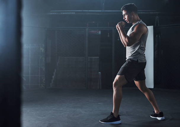 Macht weiter so, macht weiter wie bisher. ein junger Mann beim Kickboxen in einem Fitnessstudio - Foto, Bild