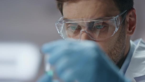 Klinik çalışanı test tüpündeki numune deneysel maddeyi analiz ediyor. Eldiven gözlüklü ciddi bir bilim adamı araştırma verilerini laboratuvar bilgisayarına giriyor. Koronavirüs aşısını inceleyen akıllı biyokimyacı.. - Video, Çekim