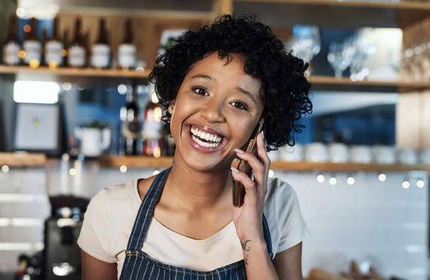 Włożenie ciężkiej pracy w dochodowy mały biznes. Portret młodej kobiety rozmawiającej przez komórkę podczas pracy w kawiarni - Zdjęcie, obraz