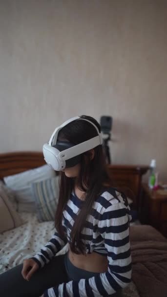 Una joven activa juega videojuegos de realidad virtual en la comodidad de su propia casa. Imágenes de alta calidad 4k - Imágenes, Vídeo