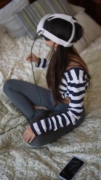 Otthon, egy kedves fiatal nő élvezi a játék szenvedély egy virtuális valóság headset. Kiváló minőségű 4k felvételek - Felvétel, videó